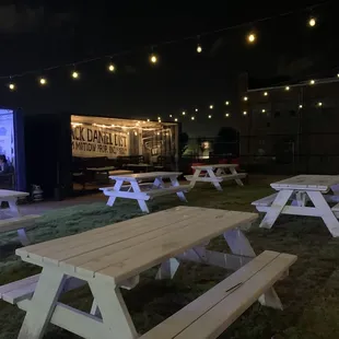 picnic tables with lights in the background