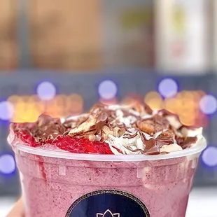 a hand holding a cup of berry smoothie