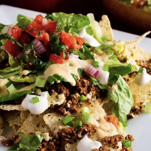 Loaded Nachos! Walnut "meat" under a bed of tortilla chips with homemade guacamole, pick de Gallo, and cashew cheese sauce.