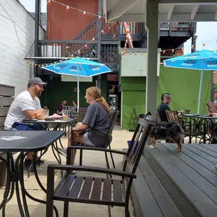 people sitting at tables with umbrellas