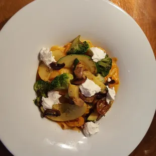 Pasta Primavera with seasonal vegetables, handmade pappardelle tossed in creamy tomato sauce topped with goat cheese
