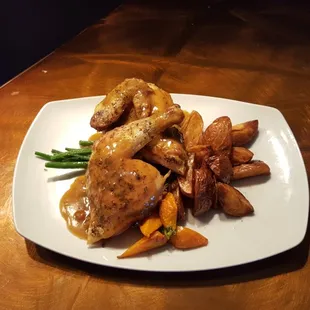Half Chicken topped with rosemary pan jus and served with roasted potatoes, haricot verts and heirloom carrots.