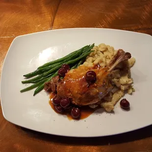 Confit Duck Leg topped with a black cherry and brandy sauce served with spatzle and haricot verts