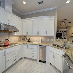 a kitchen with white cabinets and granite countertops