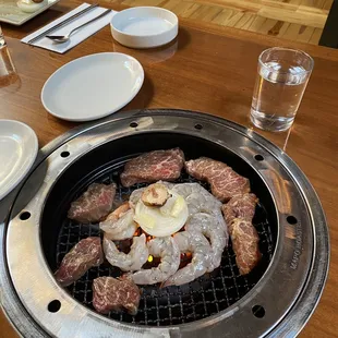 a grill with meat and shrimp on it