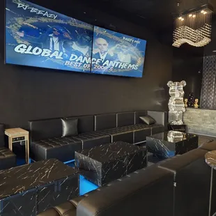 a black room with black couches and tables