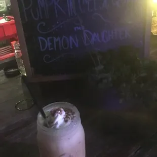 a drink with whipped cream and a straw in a mason jar