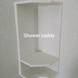 Shower caddy is attached using hot glue and a construction adhesive.  The joints are sealed with caulk.