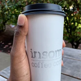 a hand holding a coffee cup