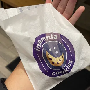 a hand holding a bag of cookies