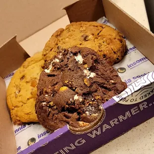 (front center)S'Mores Jumbo Deluxe Cookie,  Salted Caramel Deluxe Cookie(back left), Oatmeal Chocolate Walnut Deluxe Cookie(back right)