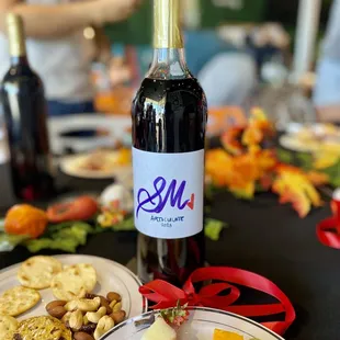 a plate of cheese, crackers, and a bottle of wine