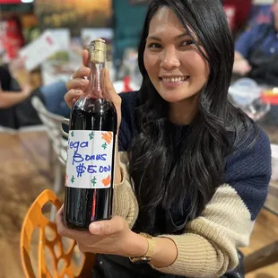 a woman holding a bottle of wine