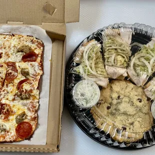 Example of a typical Sample Platter. Italian sausage &amp; peperoni pizza, turkey sub, potato salad and chocolate chip cookie.