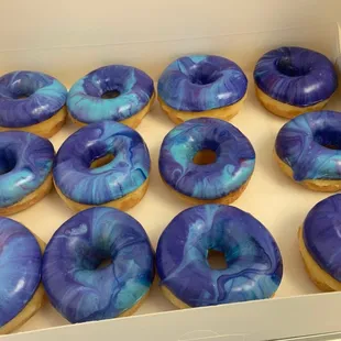 a box of blue and purple doughnuts