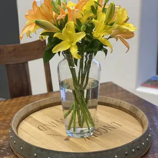 a vase of flowers on a barrel
