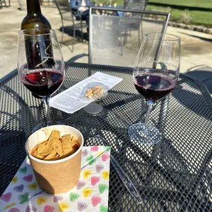 a glass of wine and a bowl of crackers