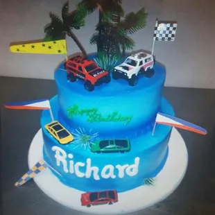  a birthday cake with cars and palm trees