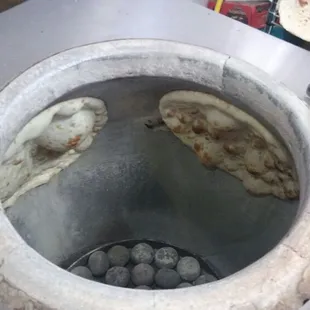 pita bread being cooked in a pot