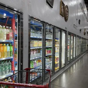 a shopping cart in front of a row of refrigerators