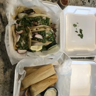 a plate of tamales and a container of tamales