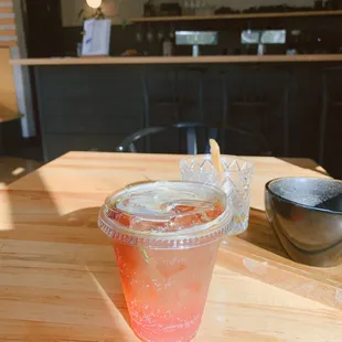 a drink in a plastic cup on a wooden table