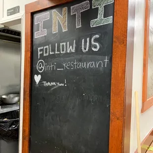 a chalk board with a sign that says ente follow us