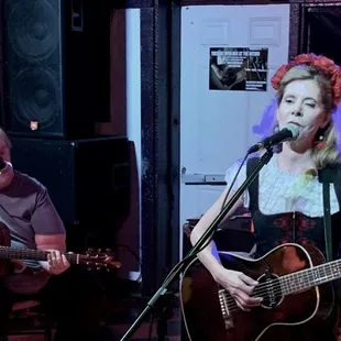 a woman playing guitar and singing