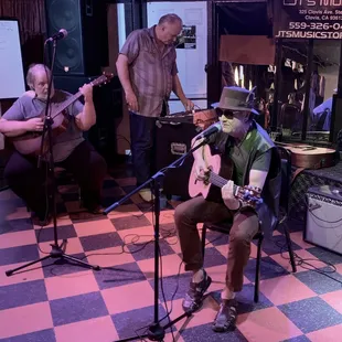 a man playing a guitar and singing
