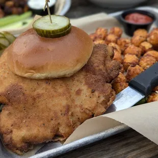 Crispy pork tenderloin sandwich with sweet potato tots.