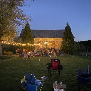 a group of people gathered outside a barn