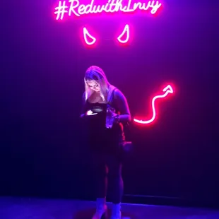 a woman standing in front of a neon sign