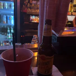 a red cup and a bottle of beer