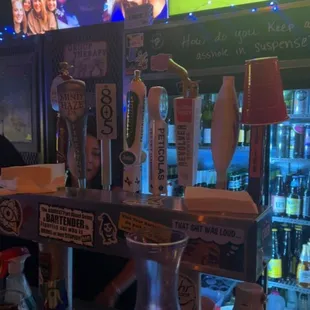 a bar with beer taps and televisions