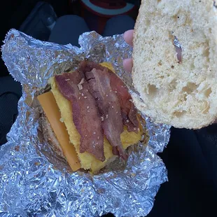 Dried out bagel with cold cheese, egg, and bacon