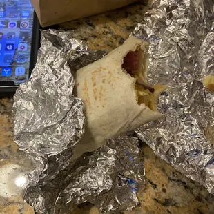 a burrito wrapped in aluminum foil