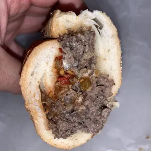 a hand holding a hamburger