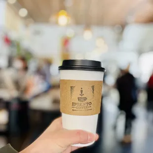 a hand holding a cup of coffee