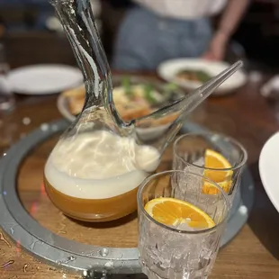 a pitcher of liquid and two glasses of orange juice