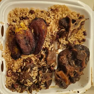 $26.39 Lg to-go dinner entrée:  oxtail w/peas and rice, fried plantains and ((ABSENT)) steamed vegetables.