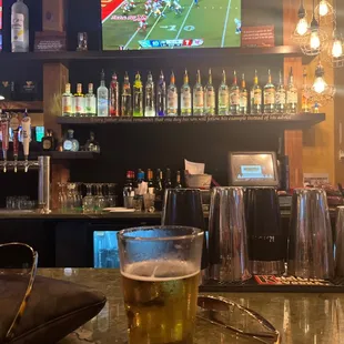 a glass of beer on a bar