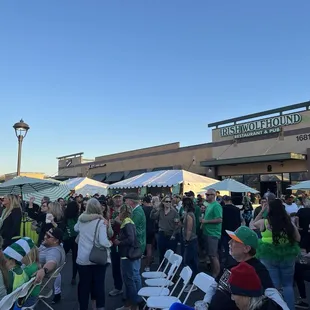 a large crowd of people sitting under umbrellas