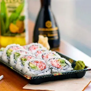 a sushi with chopsticks and a bottle of wine