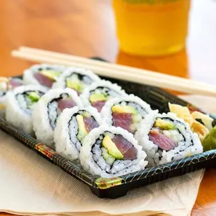 a plate of sushi and chopsticks