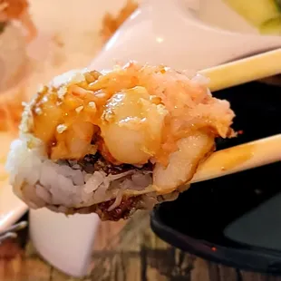 chopsticks holding a piece of sushi