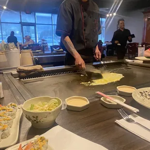 Chef doing his thg... as he cooks the fried eggs to go in the fried rice
