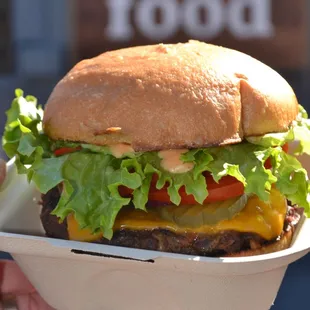 a person holding a sandwich in a styrofoam container