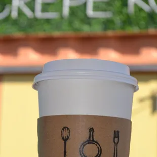 a hand holding a cup of coffee