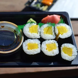 a person holding a tray of sushi