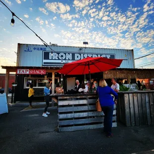 a group of people sitting at a table under an umbrella